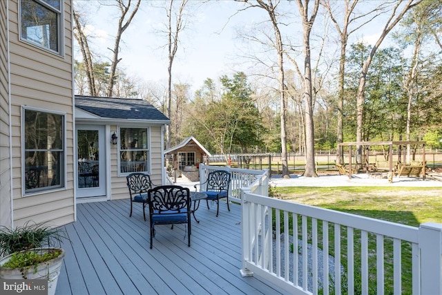 wooden deck with a playground and a yard