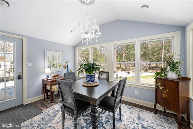 dining space featuring vaulted ceiling, dark wood-type flooring, and an inviting chandelier