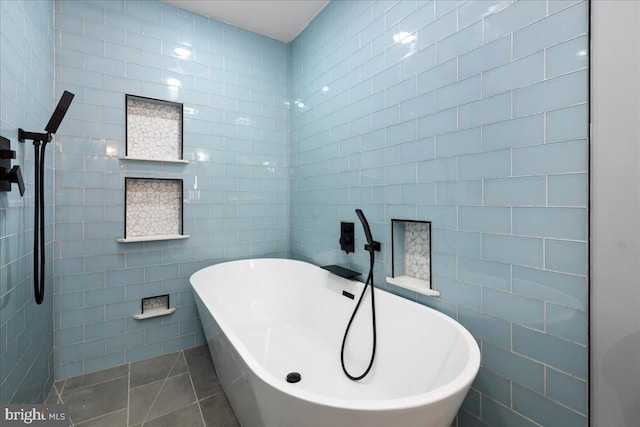 bathroom featuring tile walls, a bathtub, and tile patterned floors