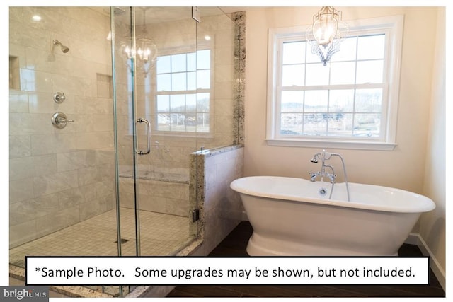 bathroom featuring separate shower and tub, a wealth of natural light, and a chandelier