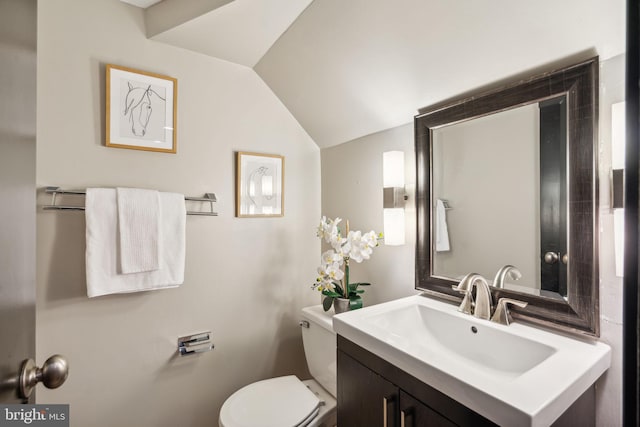 bathroom featuring vaulted ceiling, toilet, and vanity