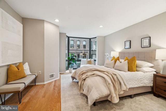 bedroom featuring a wall of windows and hardwood / wood-style floors