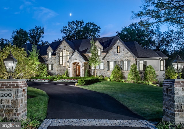 french country inspired facade with a yard