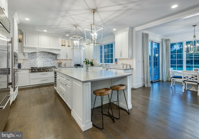 kitchen featuring stainless steel appliances, crown molding, white cabinets, dark hardwood / wood-style floors, and backsplash