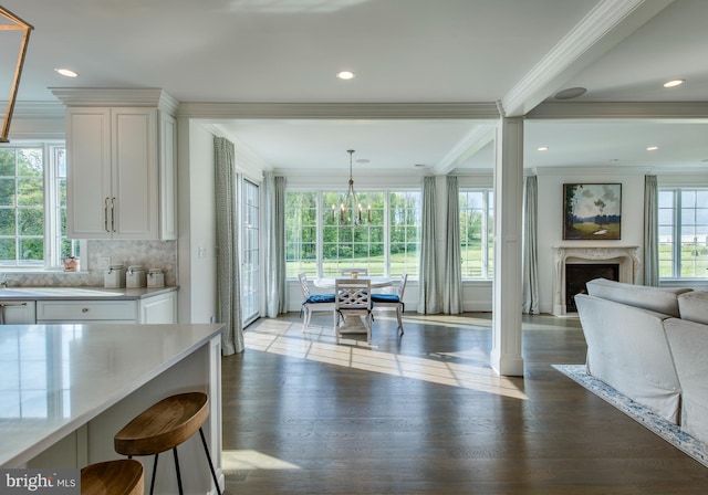 dining space featuring a wealth of natural light, a fireplace, ornamental molding, and light hardwood / wood-style floors