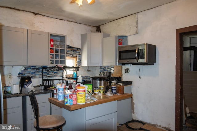 kitchen featuring sink, backsplash, and butcher block counters