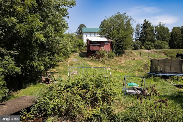 view of yard with a trampoline and a shed