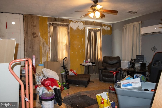 interior space featuring ceiling fan, an AC wall unit, and wood walls