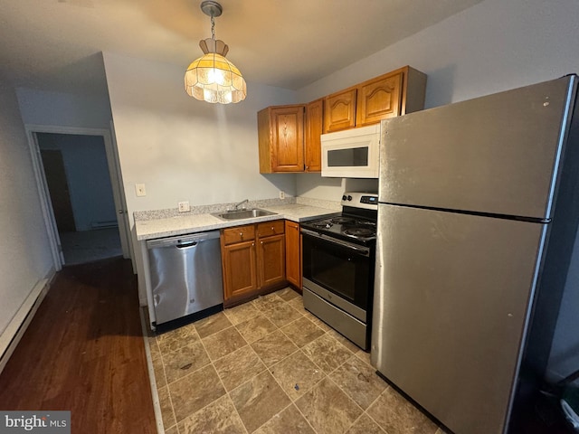 kitchen with appliances with stainless steel finishes, sink, hanging light fixtures, baseboard heating, and dark hardwood / wood-style flooring