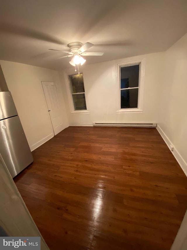 interior space with dark hardwood / wood-style flooring, a baseboard radiator, and ceiling fan