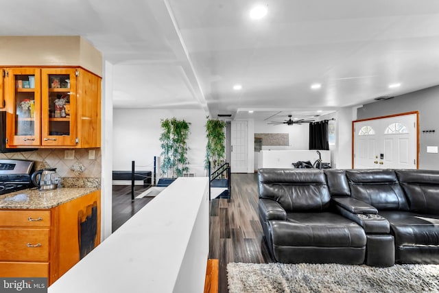 living room featuring ceiling fan and dark hardwood / wood-style floors