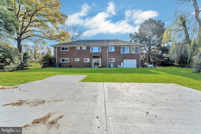 back of house featuring a garage, central air condition unit, and a yard