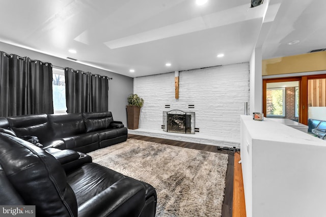 living room featuring hardwood / wood-style floors and a stone fireplace