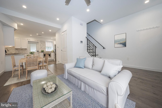 living room featuring ceiling fan and dark hardwood / wood-style floors