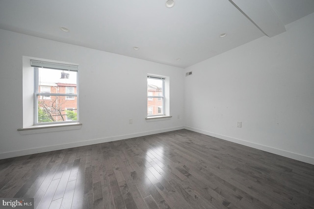 unfurnished room featuring dark hardwood / wood-style flooring and a healthy amount of sunlight