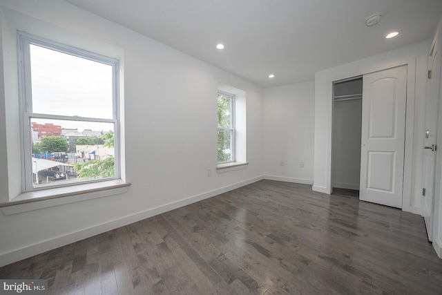 unfurnished bedroom with a closet and dark hardwood / wood-style floors