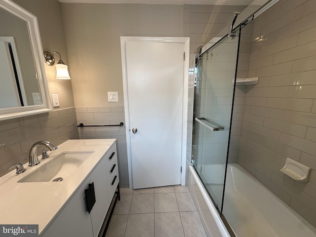 bathroom featuring tile walls, tile patterned floors, vanity, and enclosed tub / shower combo