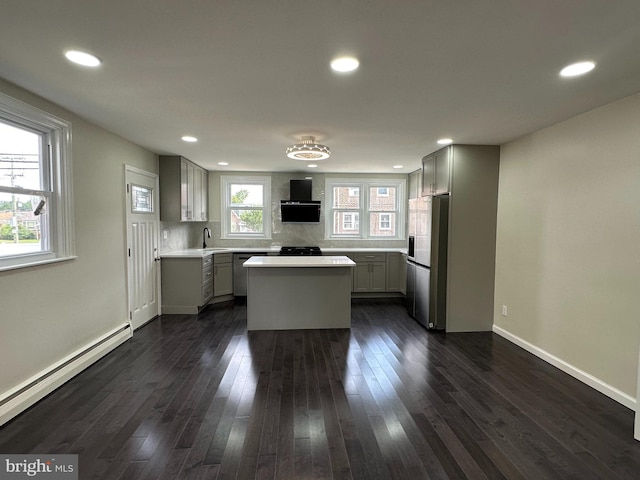 kitchen with baseboard heating, gray cabinetry, refrigerator with ice dispenser, and a kitchen island