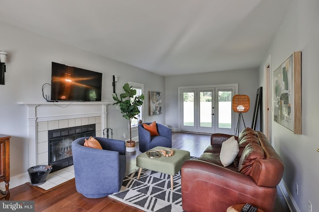 living room with light hardwood / wood-style flooring and a tiled fireplace