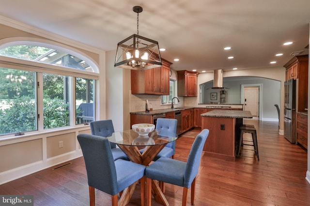 dining space featuring crown molding, dark hardwood / wood-style floors, sink, and an inviting chandelier