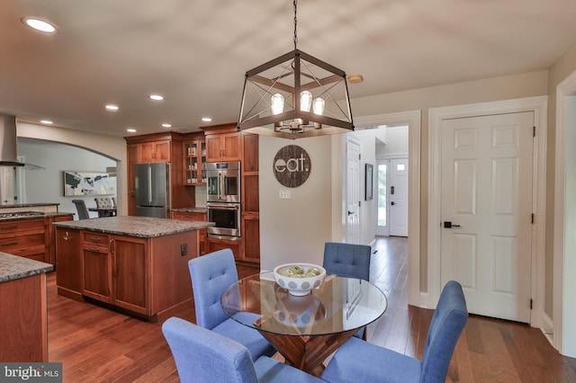 dining space featuring dark hardwood / wood-style floors and an inviting chandelier