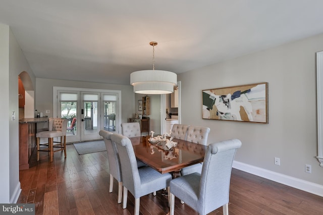 dining space with dark hardwood / wood-style floors and french doors