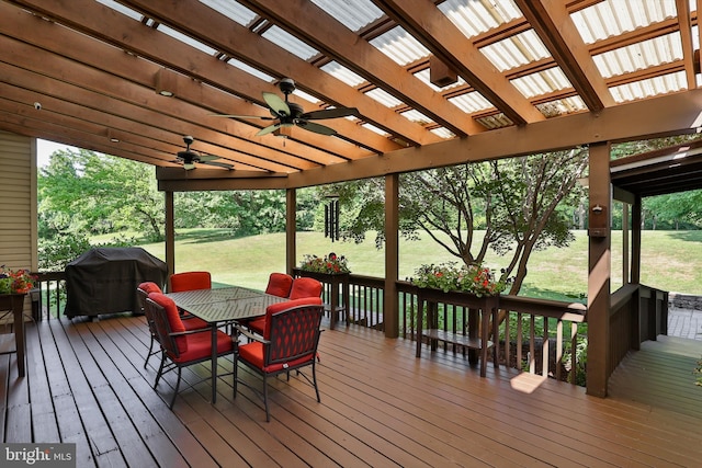 deck featuring ceiling fan, a yard, and area for grilling