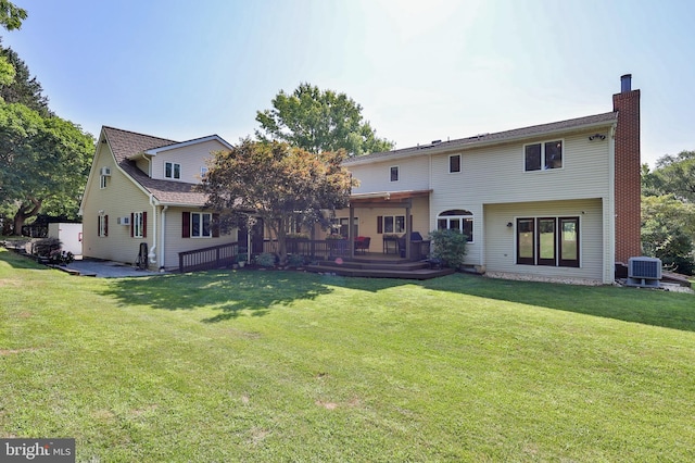 back of property featuring a deck, a yard, and central AC