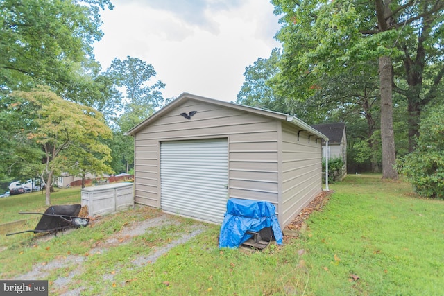 view of outdoor structure with a garage and a lawn