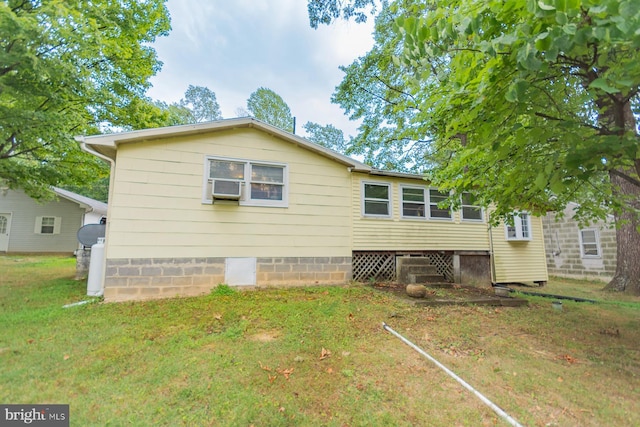 back of house with cooling unit and a yard