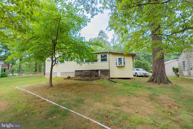 rear view of house featuring a lawn