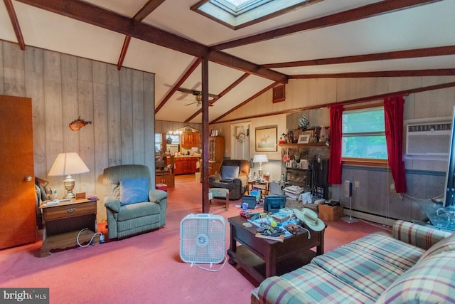 living room featuring ceiling fan, wooden walls, vaulted ceiling with skylight, and carpet