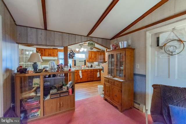 kitchen featuring baseboard heating, wooden walls, lofted ceiling with beams, and carpet