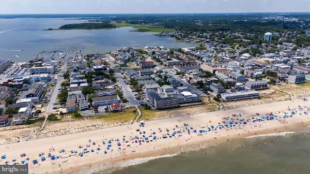 birds eye view of property with a water view and a beach view