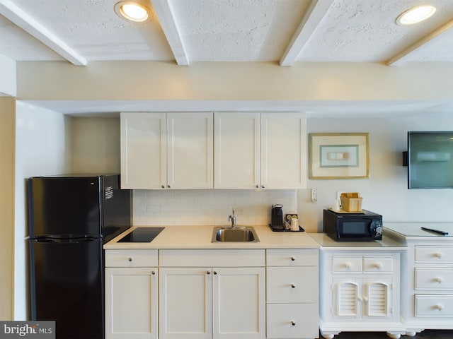 kitchen featuring sink, tasteful backsplash, black appliances, a textured ceiling, and white cabinets