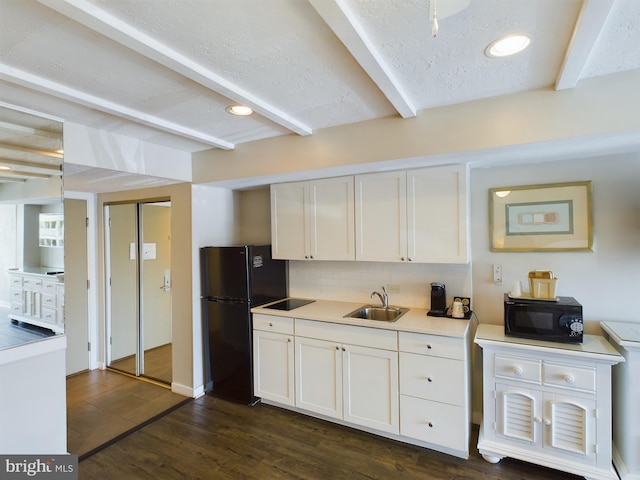 kitchen with sink, white cabinetry, black appliances, decorative backsplash, and beamed ceiling