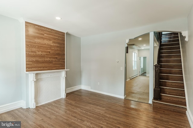 unfurnished living room with baseboard heating and wood-type flooring