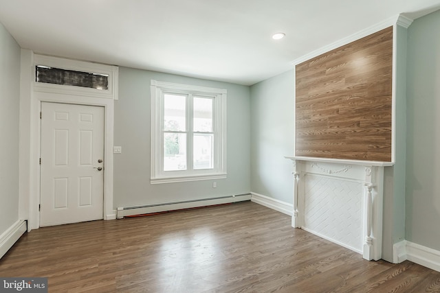 unfurnished living room featuring hardwood / wood-style flooring and a baseboard heating unit