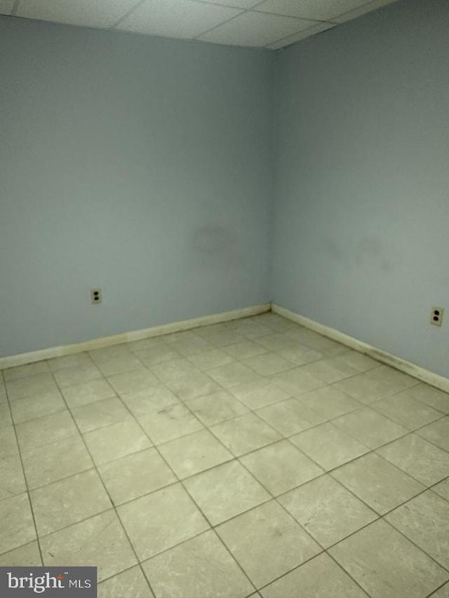 unfurnished room featuring light tile patterned flooring and a paneled ceiling