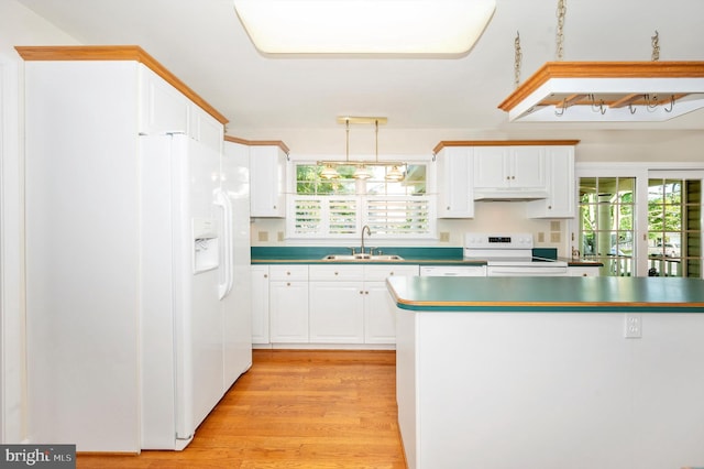 kitchen with sink, light wood-type flooring, white appliances, premium range hood, and pendant lighting