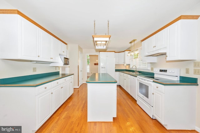 kitchen featuring light wood-type flooring, sink, decorative light fixtures, a center island, and white appliances