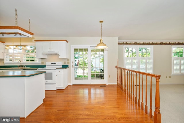 kitchen with light hardwood / wood-style flooring, premium range hood, white cabinetry, white range with electric stovetop, and pendant lighting