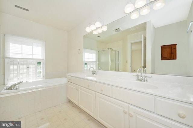 bathroom featuring a wealth of natural light, separate shower and tub, vanity, and tile patterned floors