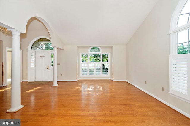 entrance foyer featuring decorative columns, light hardwood / wood-style flooring, and a healthy amount of sunlight