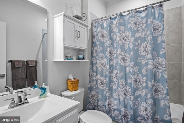 bathroom with toilet, vanity, and a shower with shower curtain