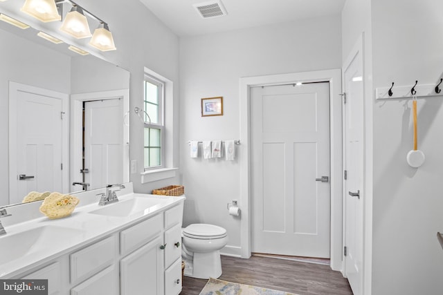 bathroom with toilet, hardwood / wood-style flooring, and vanity