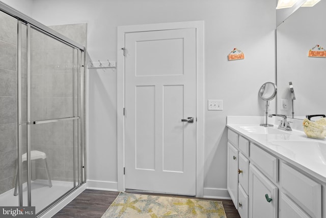 bathroom featuring hardwood / wood-style flooring, an enclosed shower, and vanity