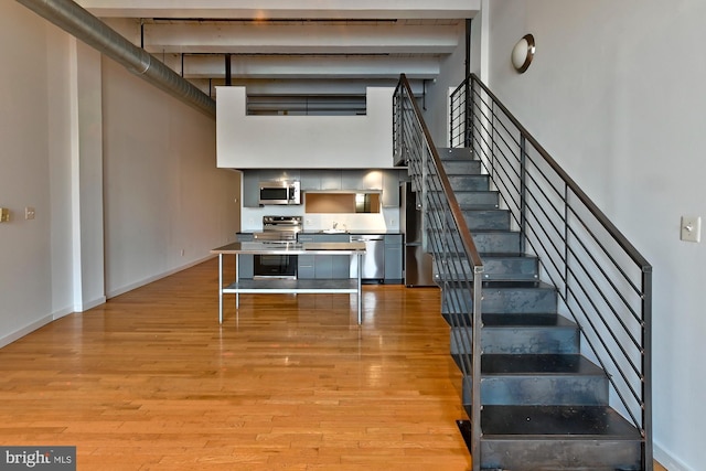 staircase featuring a high ceiling and wood-type flooring