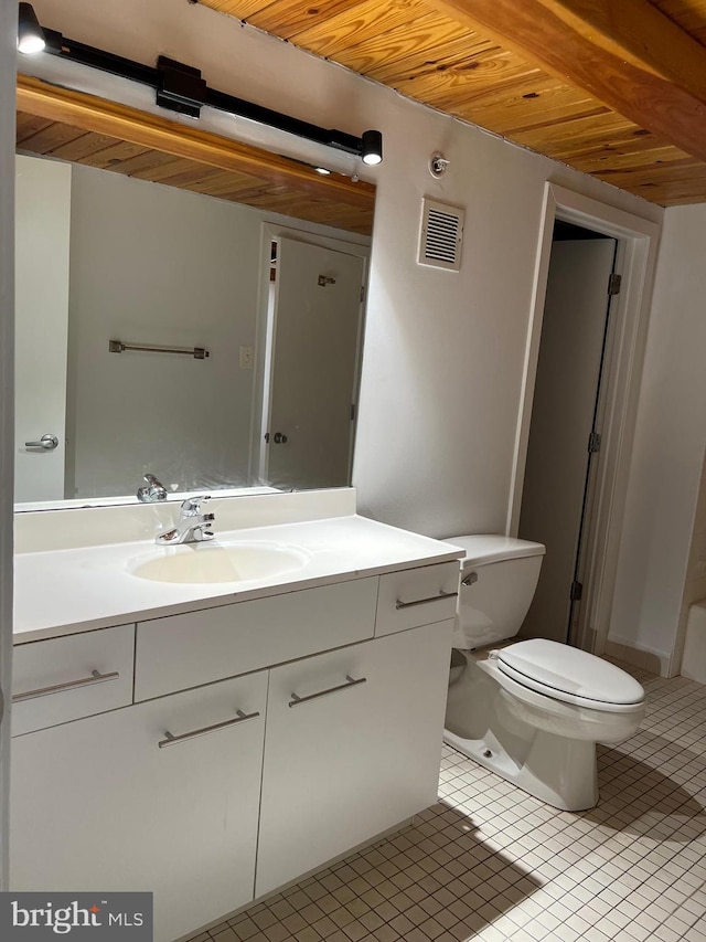 bathroom with toilet, vanity, and tile patterned floors