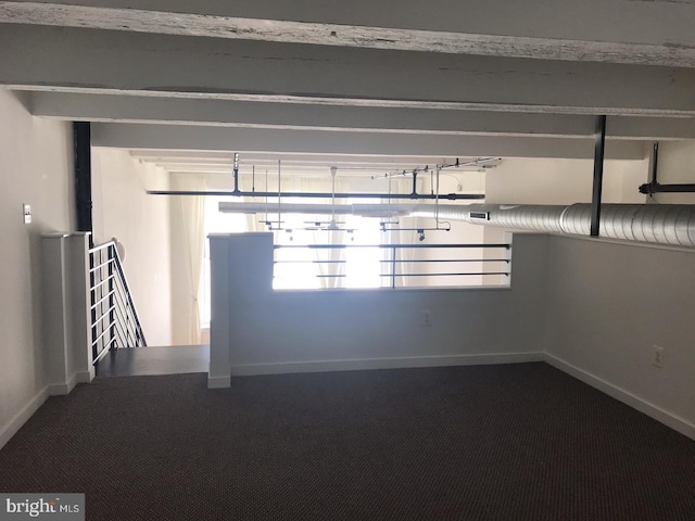 carpeted spare room with beam ceiling